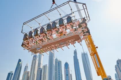 A lift elevating diners high above the ground, part of the Dinner In The Sky experience, showcasing a stunning sky view.